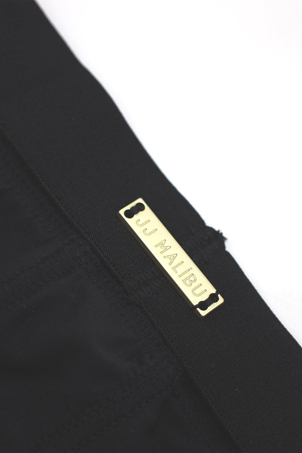 Black on-display jockstrap featuring a gold-tone rectangular jj malibu label on soft fabric