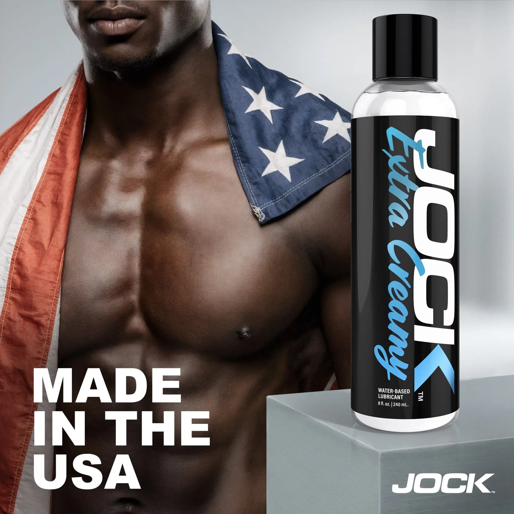 JOCK Extra Creamy 8oz lubricant bottle next to a muscular man draped in an American flag, labeled "Made in the USA."