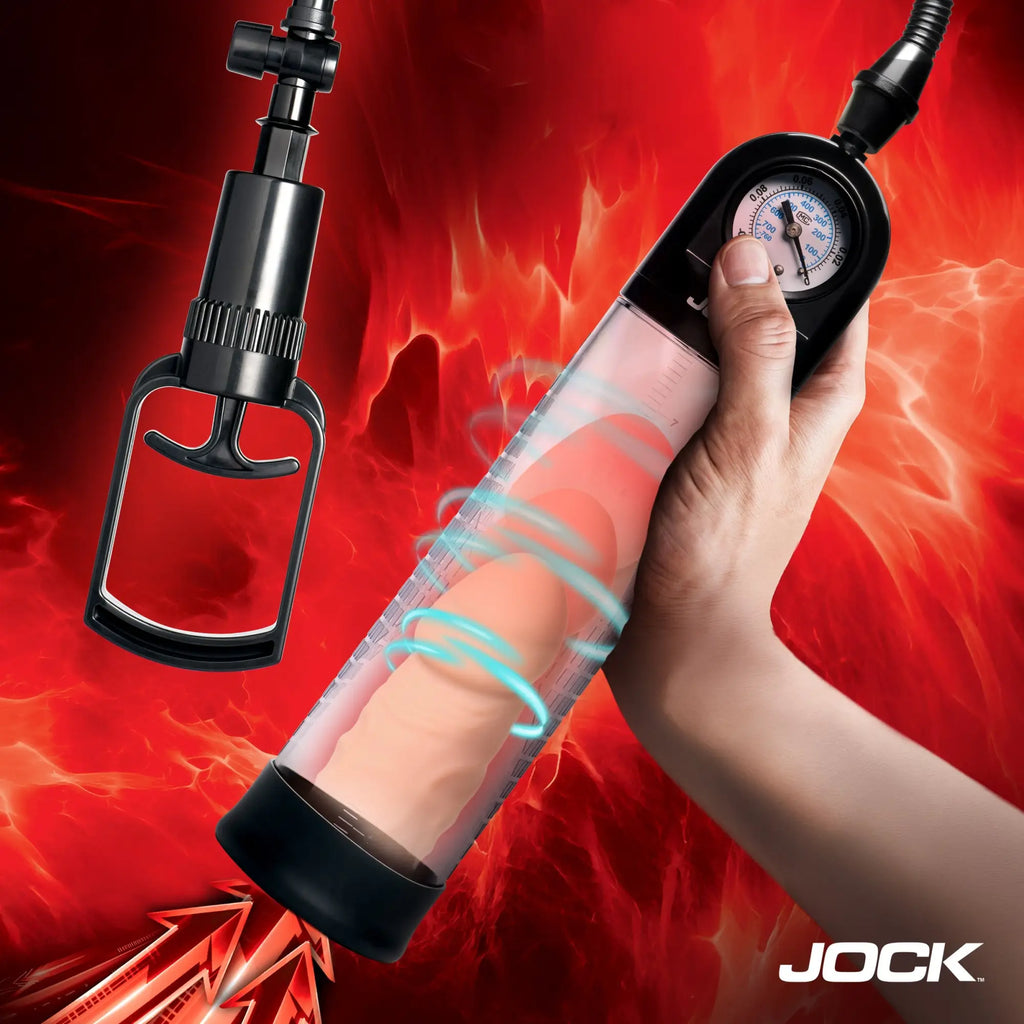 Jock Pump Up Gauge penis pump, clear cylinder with black handle and gauge, shown held against a red fiery background.