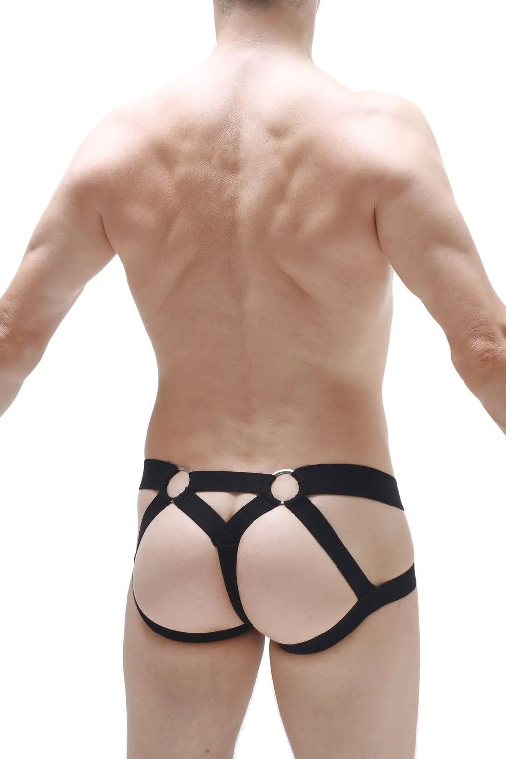 Back view of jockstring brest black harness-style briefs in black leather-like material with circular metal rings