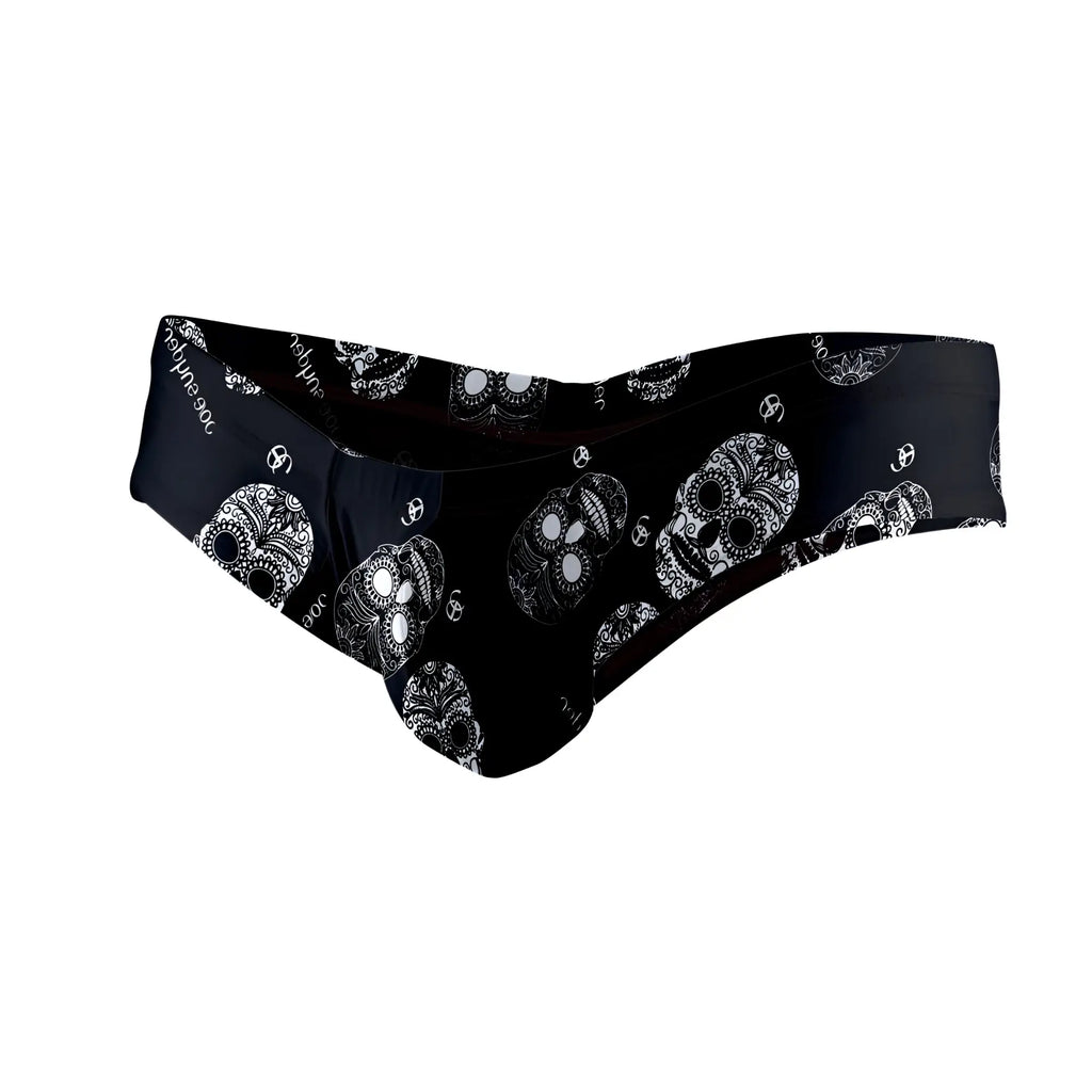 Black Joe Snyder polyester mini cheek swim trunks with a bold white sugar skull pattern front view