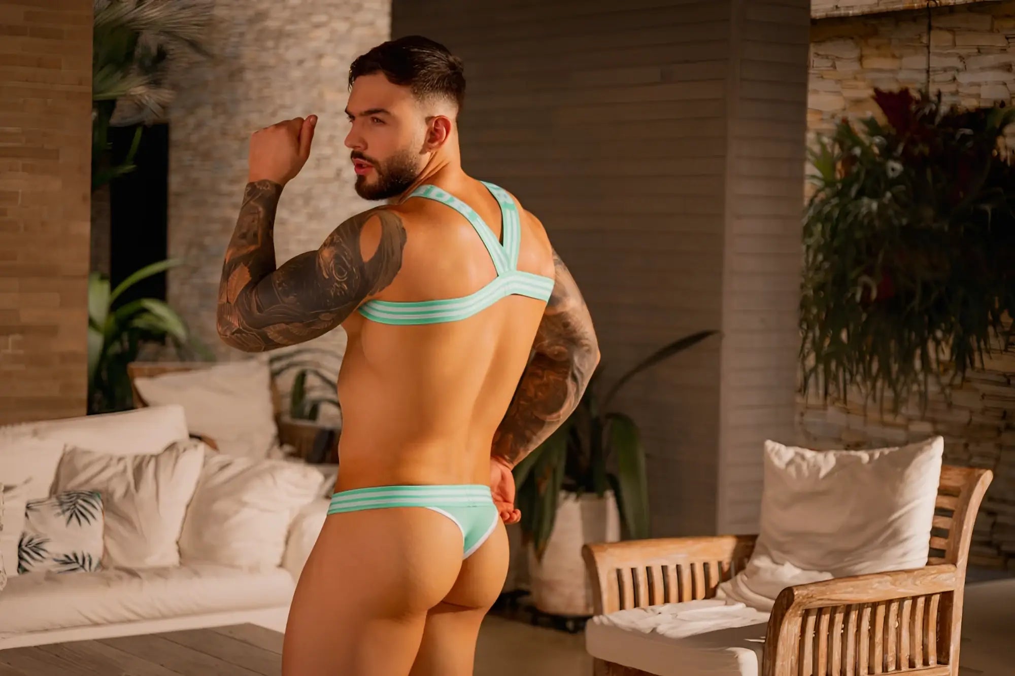 A man wearing a mint color jor 2323 college thongs strappy bikini underwear set with thin fabric straps and snug fit