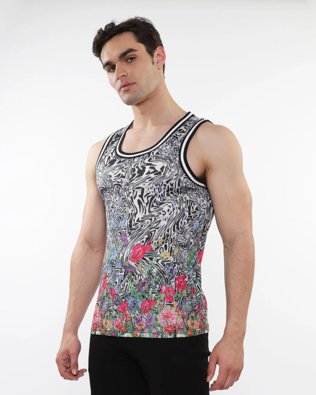 A men’s sleeveless jungle printed mesh tank with black and white swirl pattern and vibrant floral design near the hem