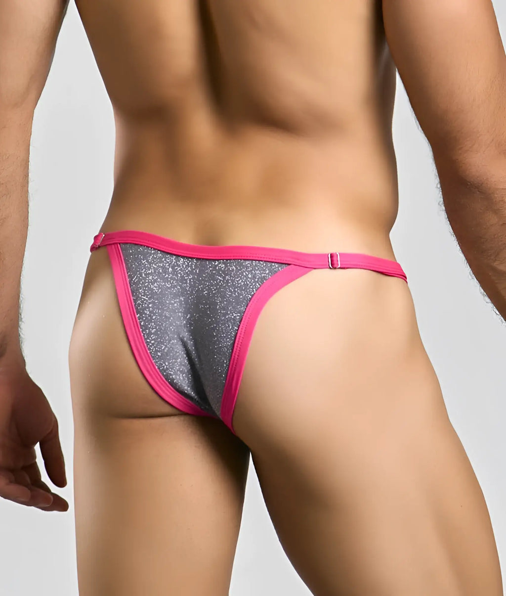 A vibrant pink and silver glitter thong from the justin + simon bikini one collection with a snug fit