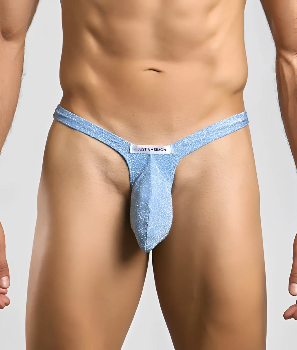 Light blue glittery bulge thong with white justin + simon brand tag designed for a bold look