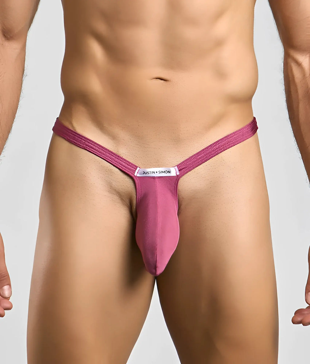 A magenta form-fitting thong with a central pouch and white justin + simon label for bulge enhancement