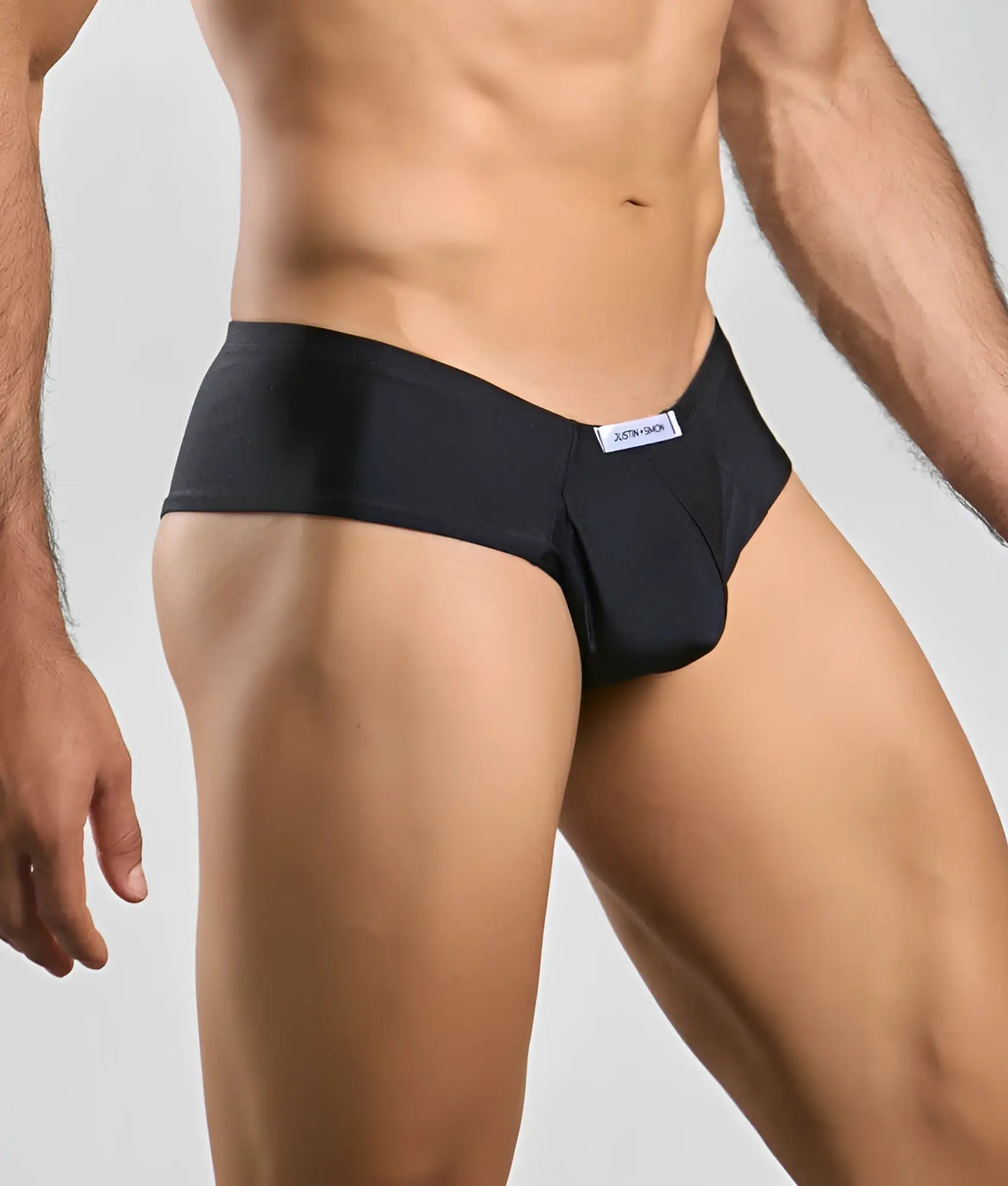 Black jockstrap by justin simon cheek with sleek form-fitting design and subtle white brand tag at waistband