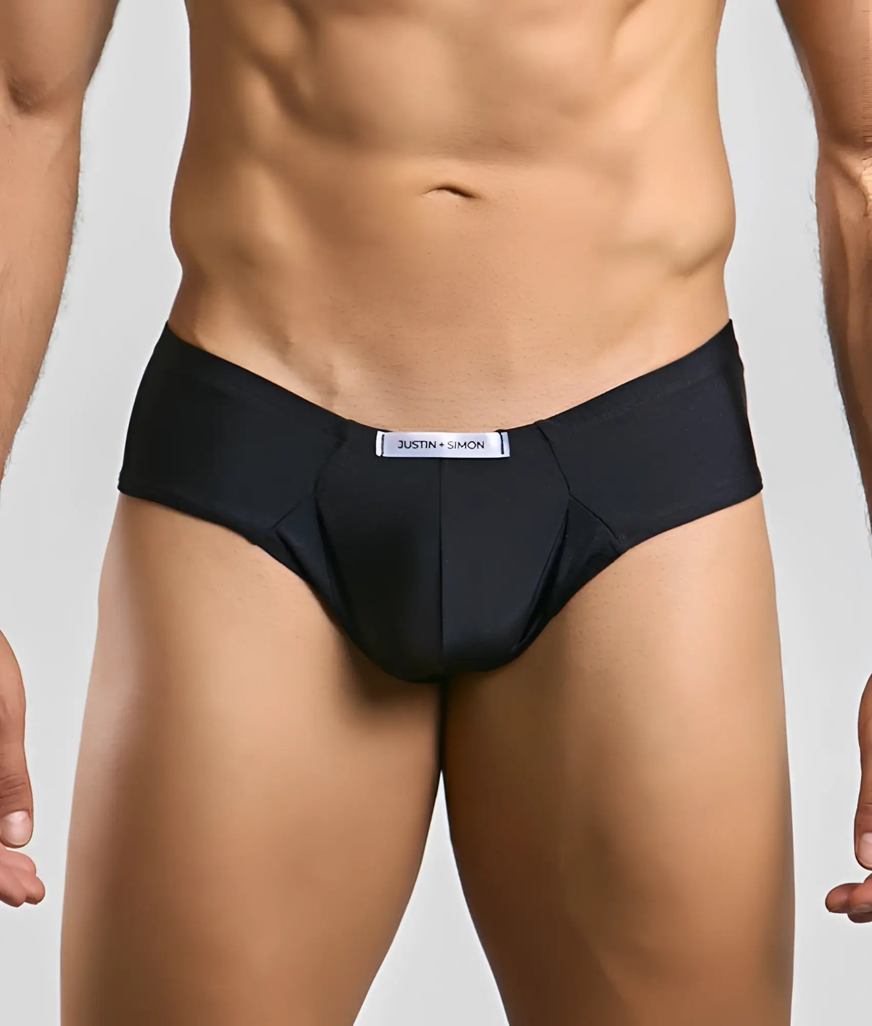 Black justin simon cheek briefs with sleek form-fitting design and subtle brand tag at the waistband