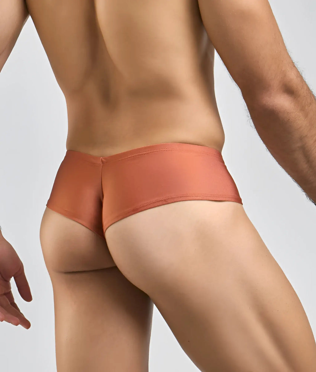 Coral-colored sleek-fitting men’s briefs made from smooth stretchy fabric in the Justin plus Simon cheek style