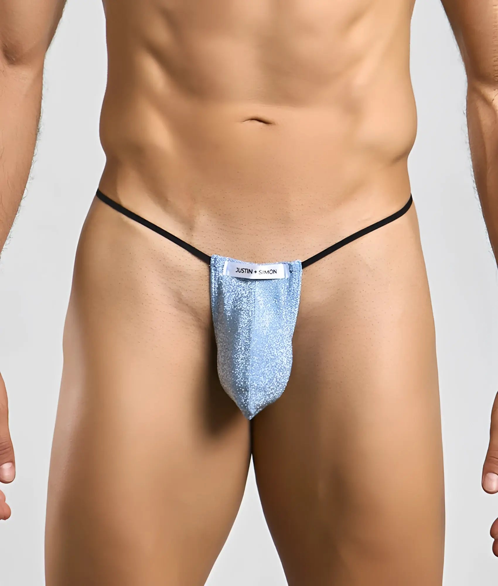 A shimmering light blue glittery classic g-string bulge with black elastic straps and a justin + simon label