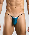 Teal justin simon classic g-string bulge with black elastic straps and white brand label showing front side