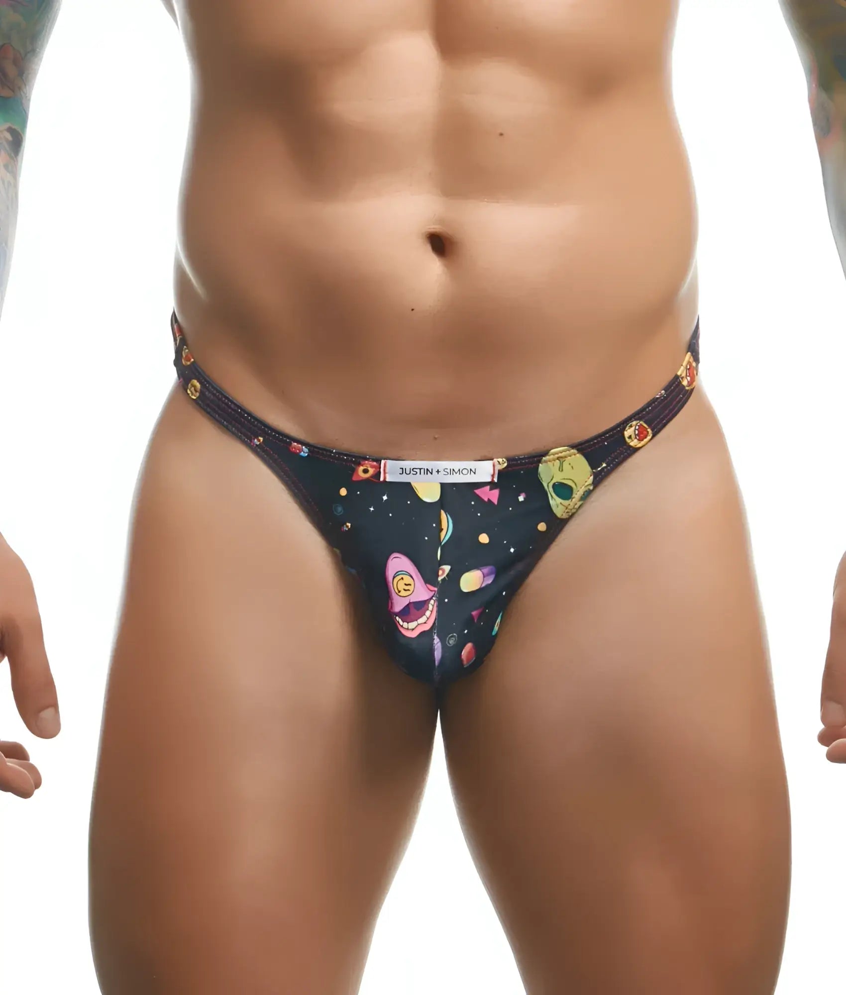 Black thong from justin + simon classic tanga fun prints featuring vibrant cosmic alien faces planets and geometric shapes