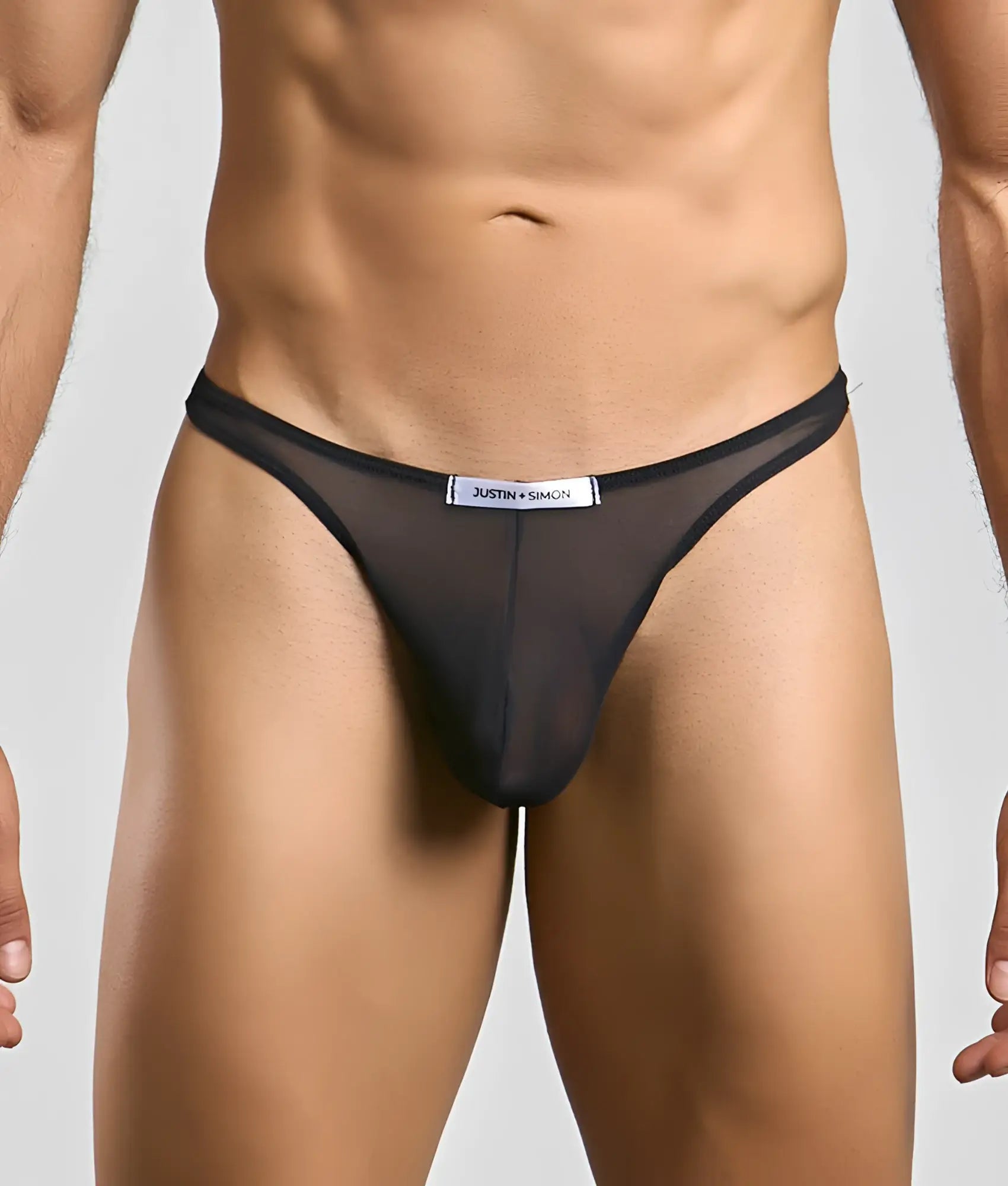 Black sheer mesh thong with white justin + simon label at the waistband from the classic tanga mesh collection