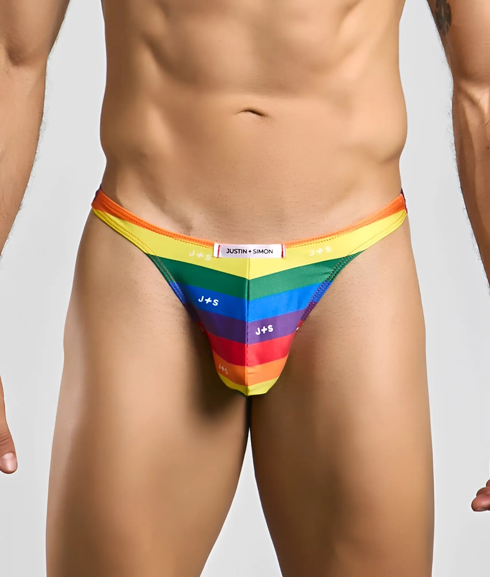 Rainbow-striped men’s thong by justin + simon with bold vibrant colors and sleek form-fitting design front view