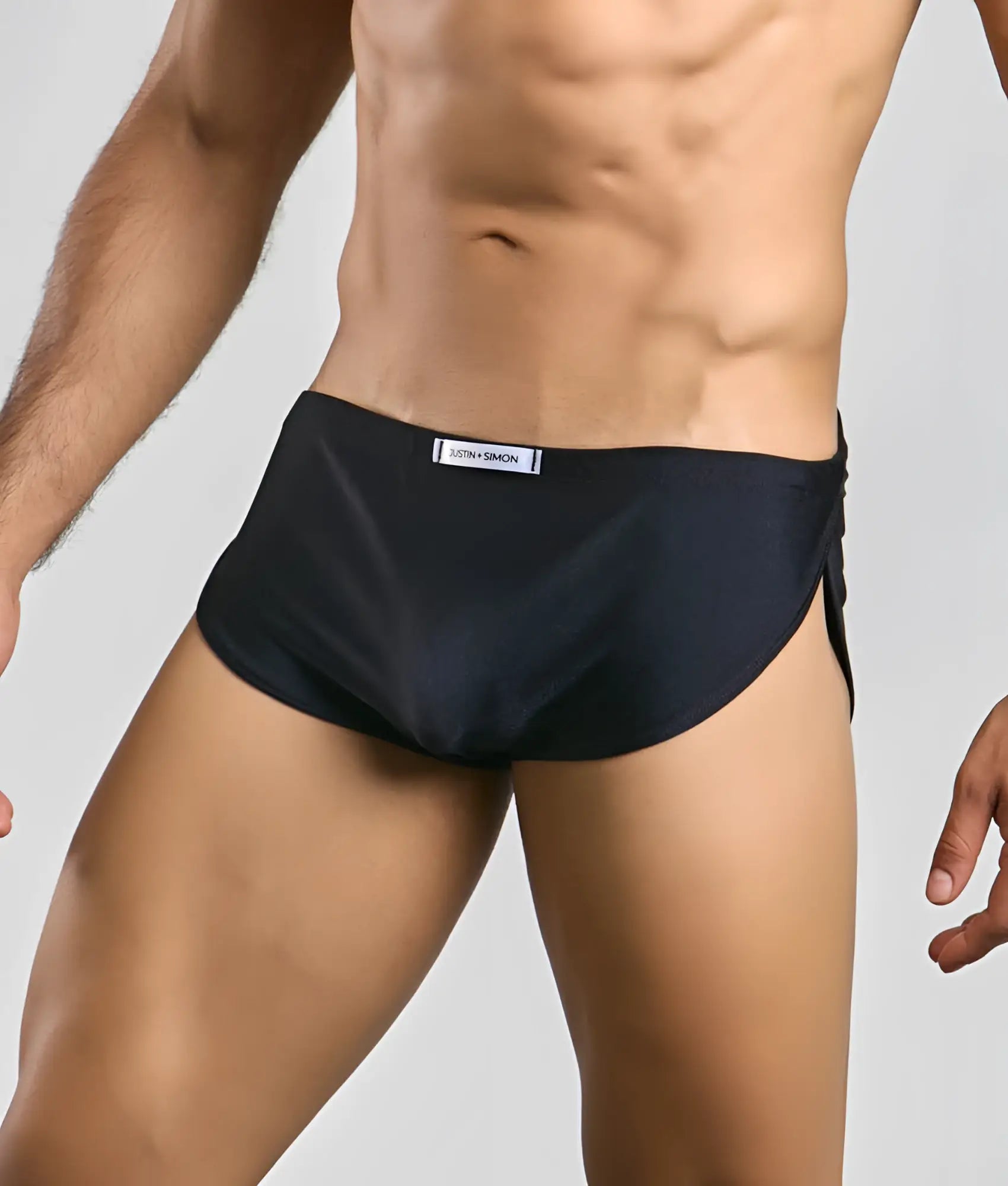 Black athletic briefs with sleek form-fitting design and subtle side slit from justin + simon running short collection