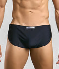Black justin simon running short with subtle textured fabric and white label at the waistband