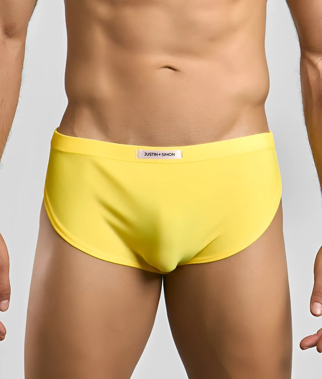 Bright yellow Justin Simon men’s briefs with smooth form-fitting fabric and subtle brand label on the waistband