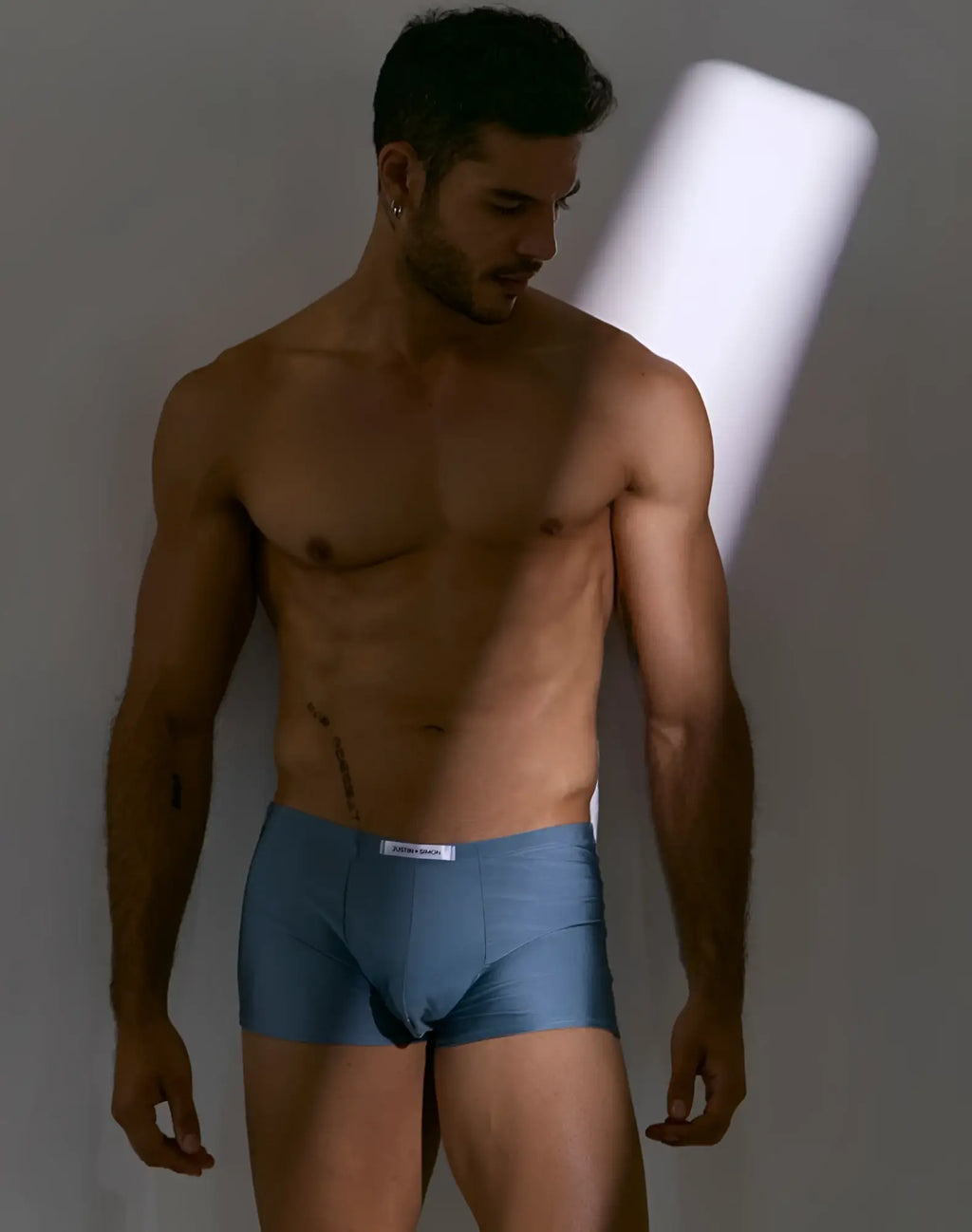Blue cotton briefs with a white brand label at the waistband from justin simon xsj08 classic boxer metal green collection