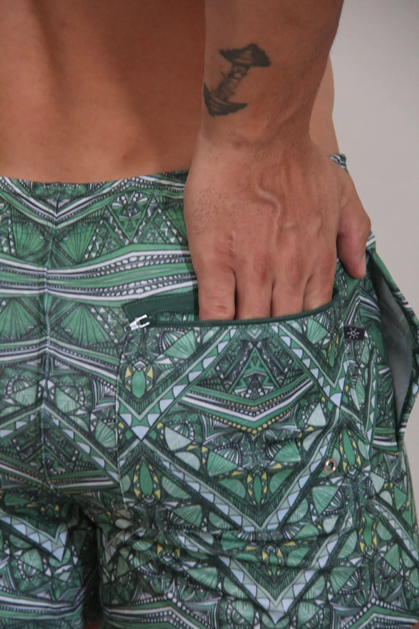 Kaleidoscope shorts green patterned swim trunks with geometric tribal designs in green black white and yellow
