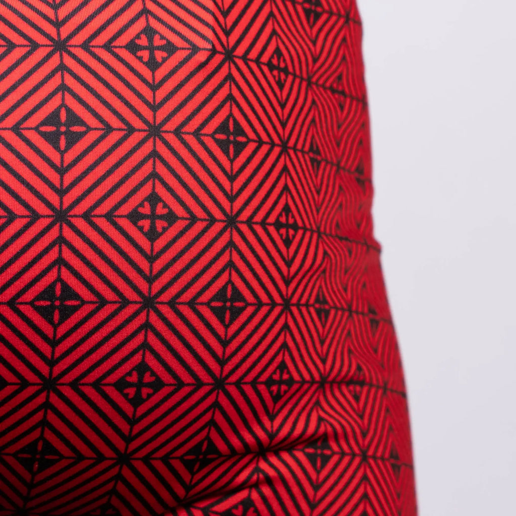 Red fabric kaleidoscope sq cut trunk with bold black geometric interlocking diamond and cross pattern
