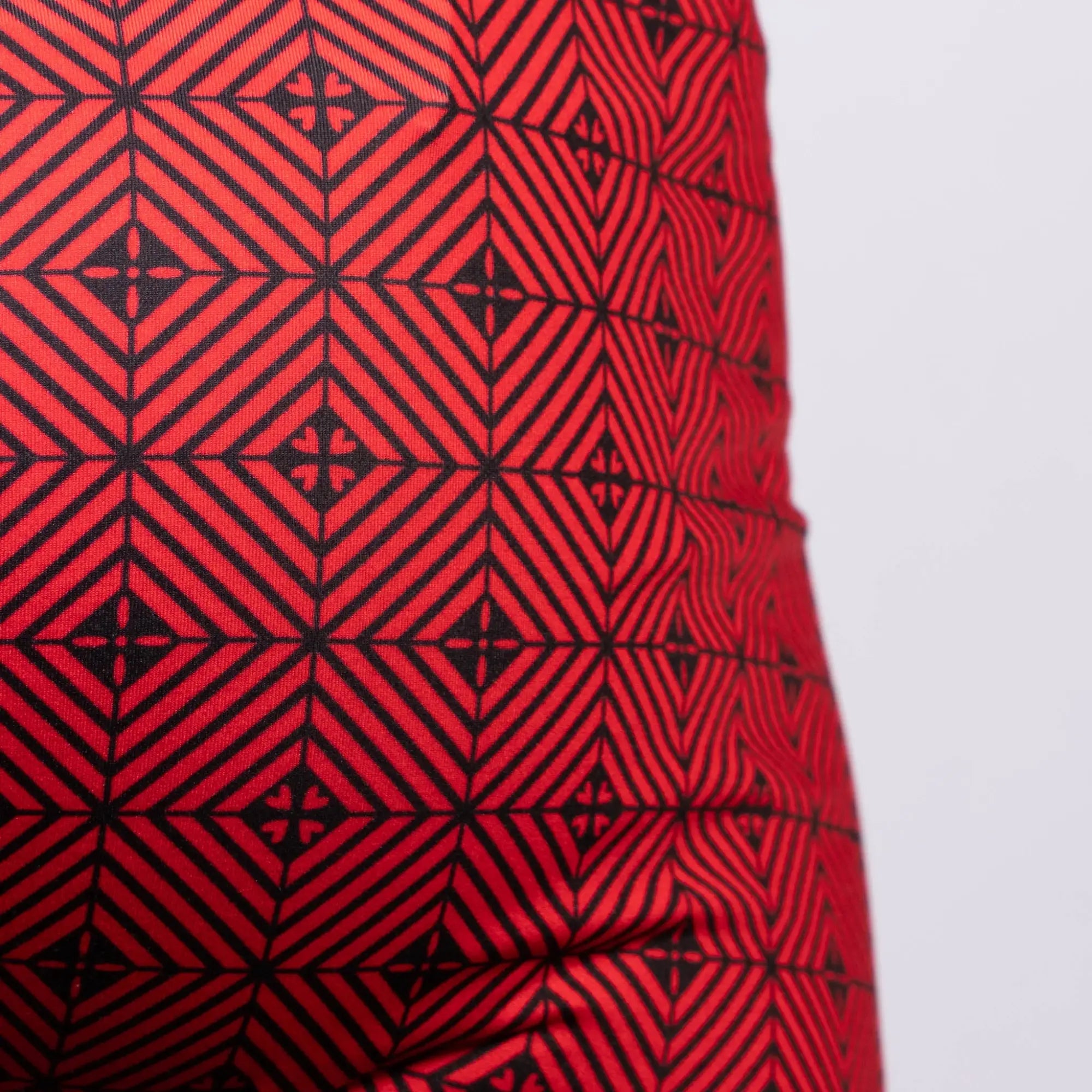 Red fabric kaleidoscope sq cut trunk with bold black geometric interlocking diamond and cross pattern