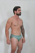 Green patterned kaleidoscope swim brief with intricate geometric designs perfect for beach and pool use