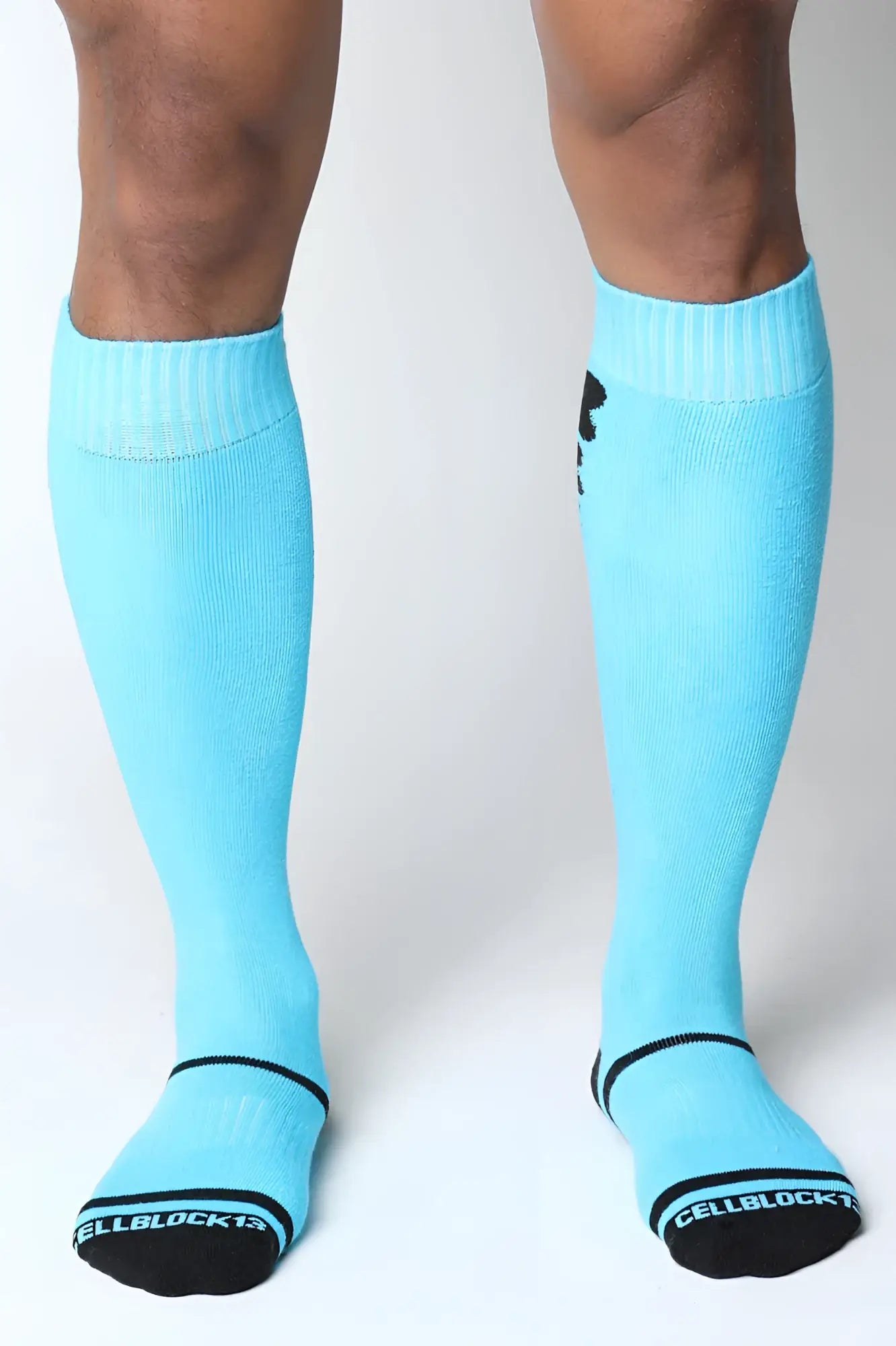 Light blue knee high socks with black trim and logo featuring cellblock13 branding on the sole from kennel club bones collection