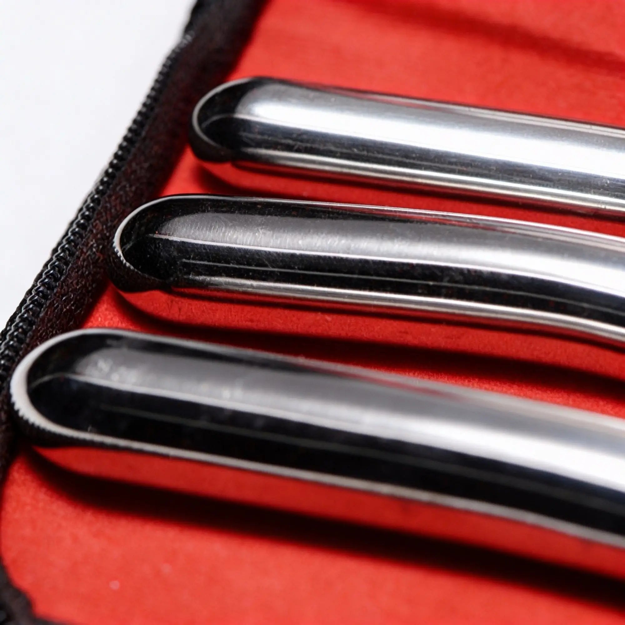 Kink Industries Hegar 8-inch silver stainless steel urethral sounds arranged in a black case with red lining.