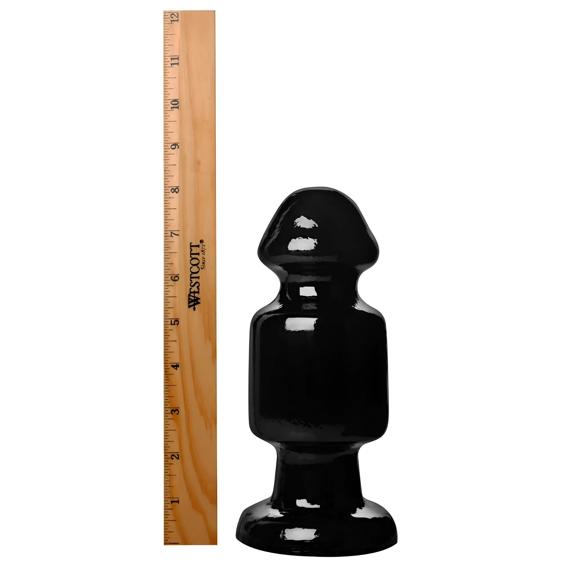 Kink Industries The Keg butt plug in solid black beside a wooden ruler for scale on a white background.