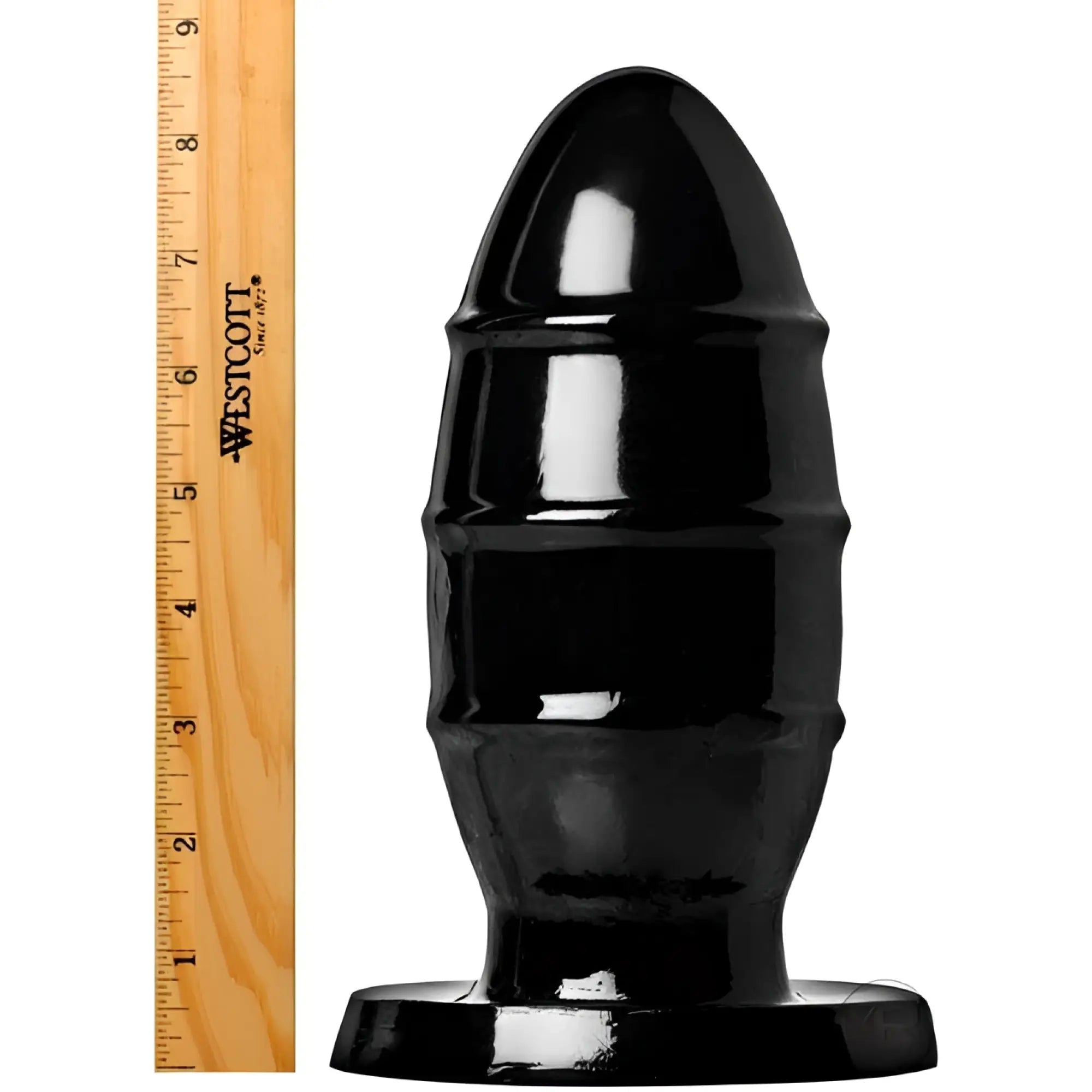Kink Industries PVC Missile butt plug in shiny black, shown with a wooden ruler for scale on a white background.