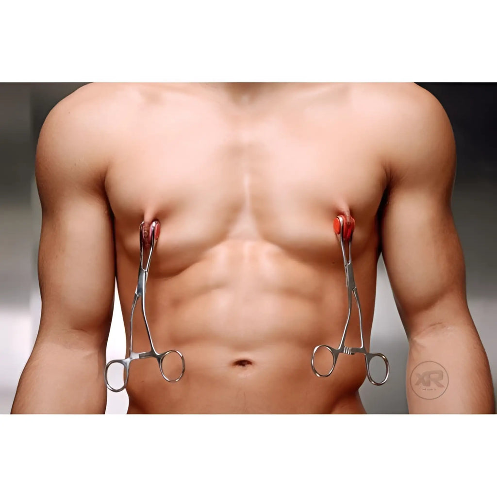 Kink Industries Young Forceps: silver metal clamps with red silicone tips attached to nipples on a bare male chest.