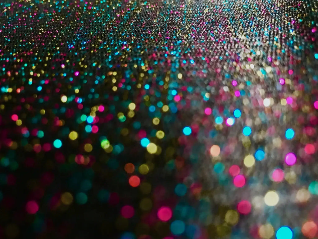 A vibrant glitter mesh tank with a multicolored shimmering surface in pink blue gold and teal shades