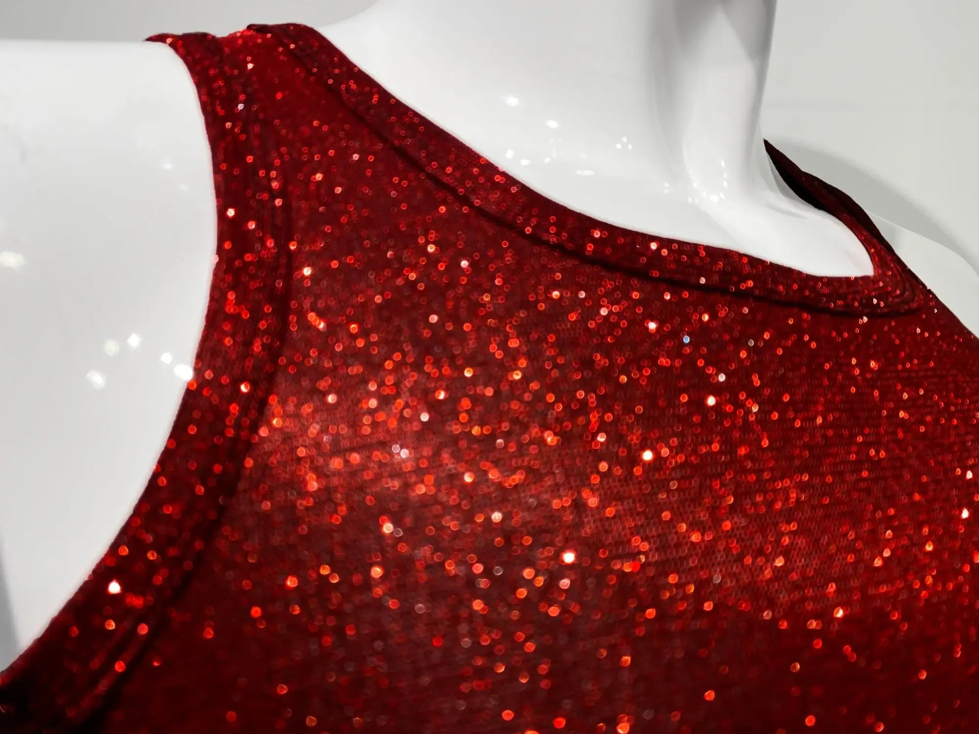 A vibrant red sequined sleeveless top with shimmering glittery texture called glitter tank