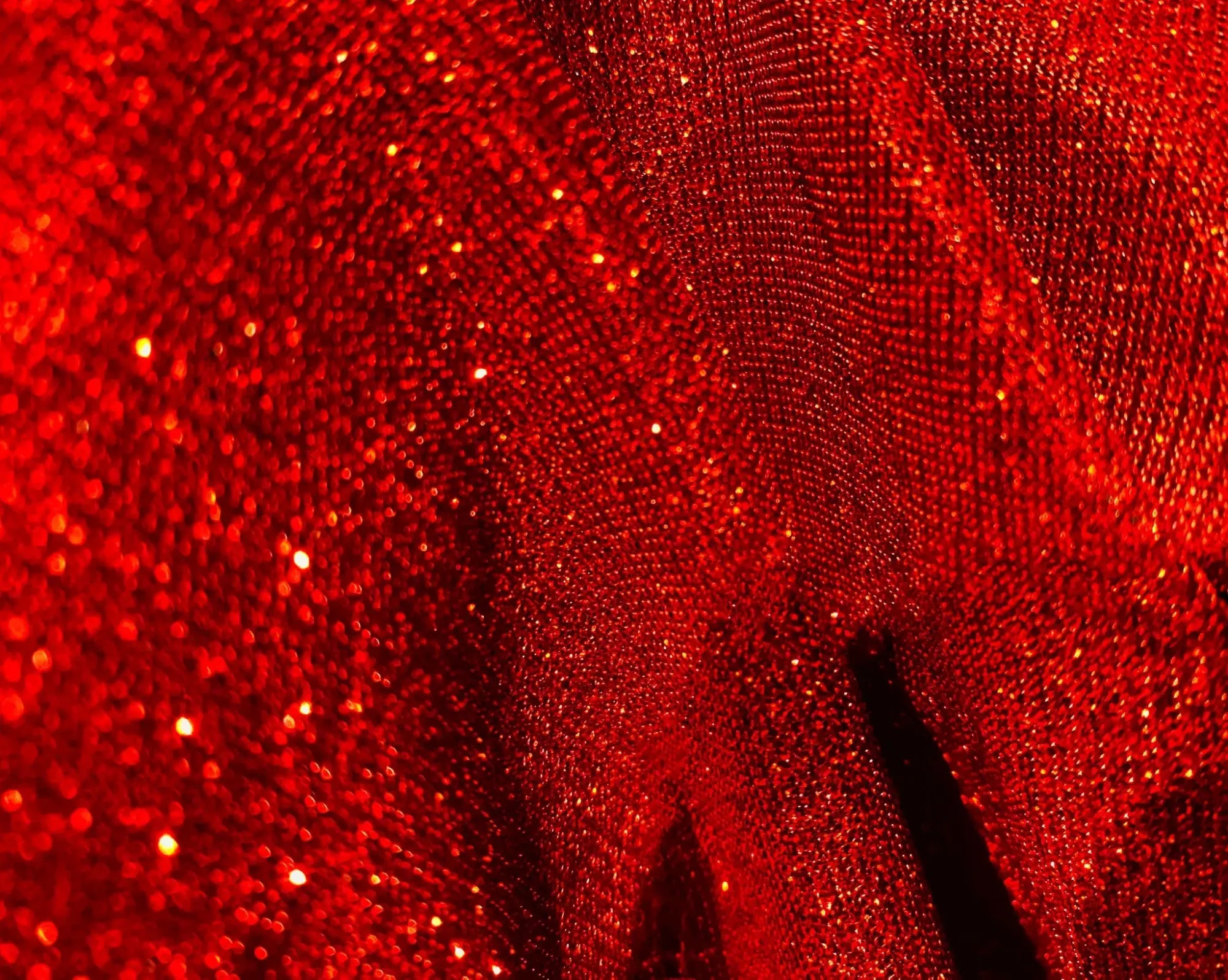 Vibrant red glitter tee fabric with a textured shimmering surface ideal for stylish festive wear