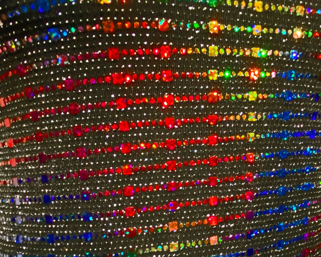 A shimmering black rainbow sequin tank with vibrant rhinestones arranged in diagonal rows on fabric