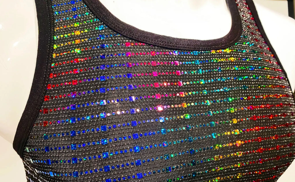 A black sequined tank top with vibrant rainbow-colored rhinestones in diagonal stripes called rainbow sequined tank