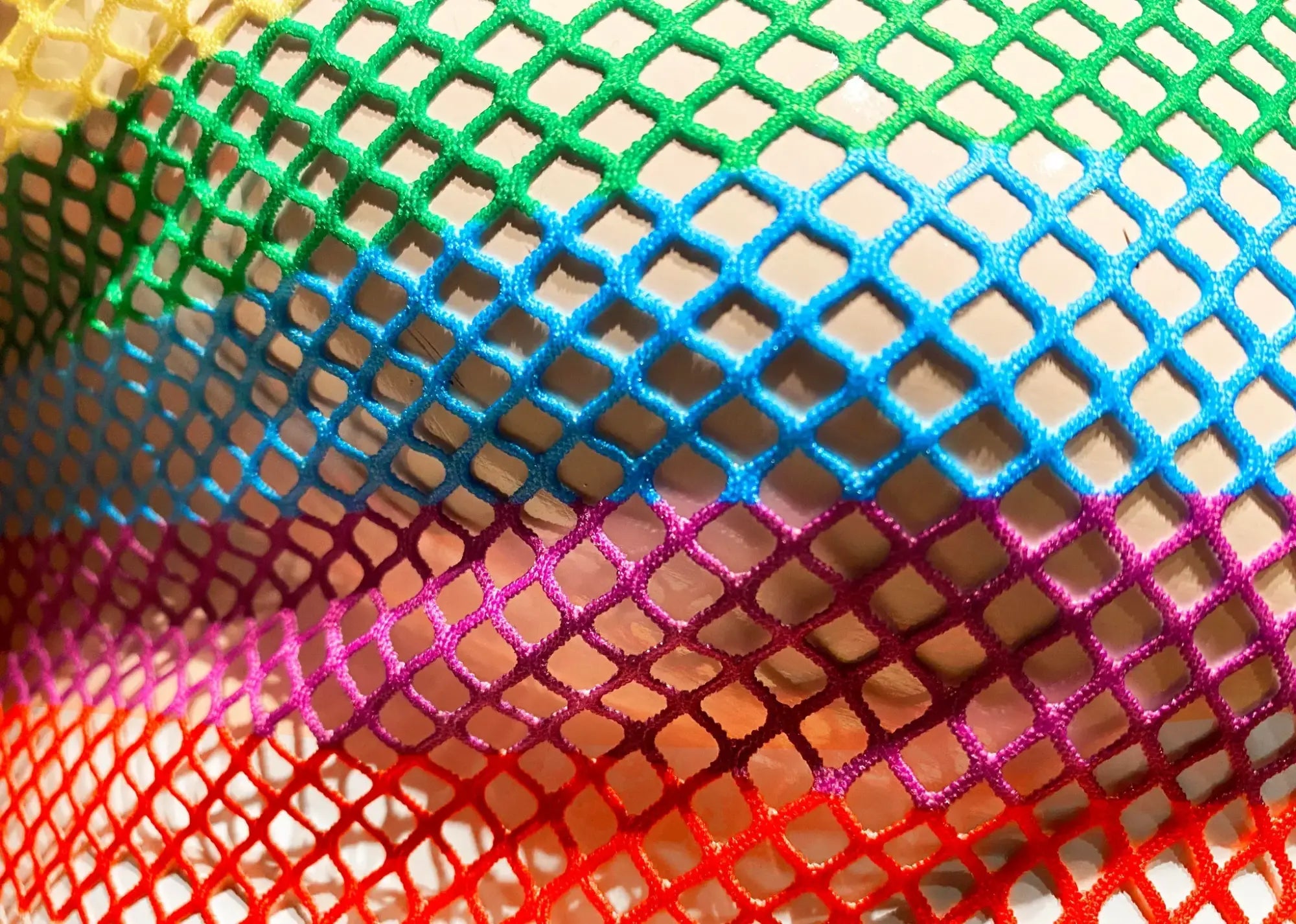 A vibrant rainbow stripe fine mesh tee with diamond-shaped colorful mesh netting fabric detail