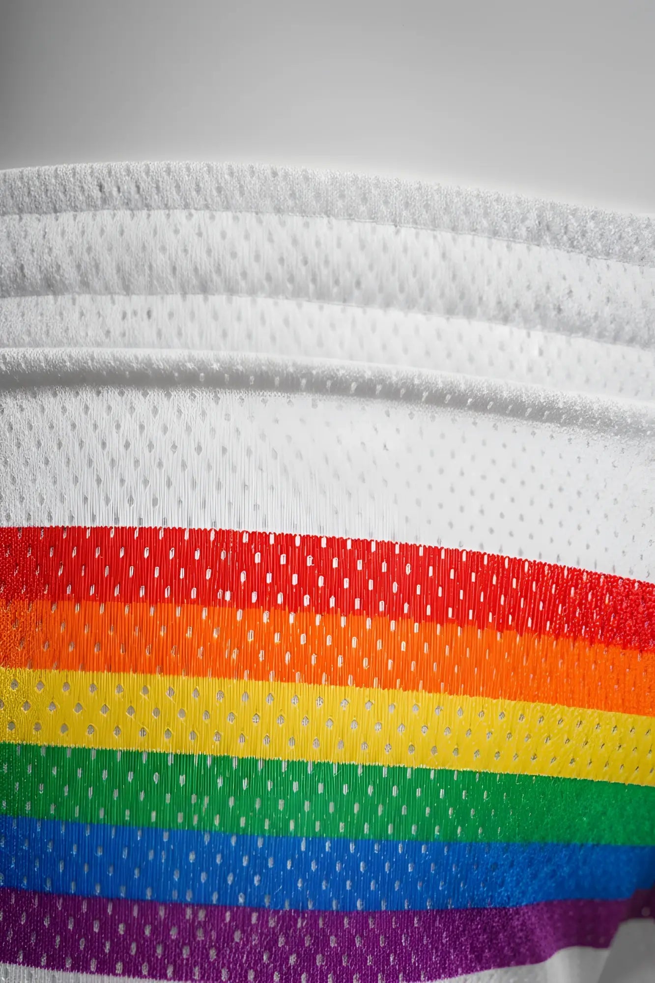 White mesh athletic shorts by KNOBS SF featuring bold rainbow stripes in red orange yellow green blue and purple