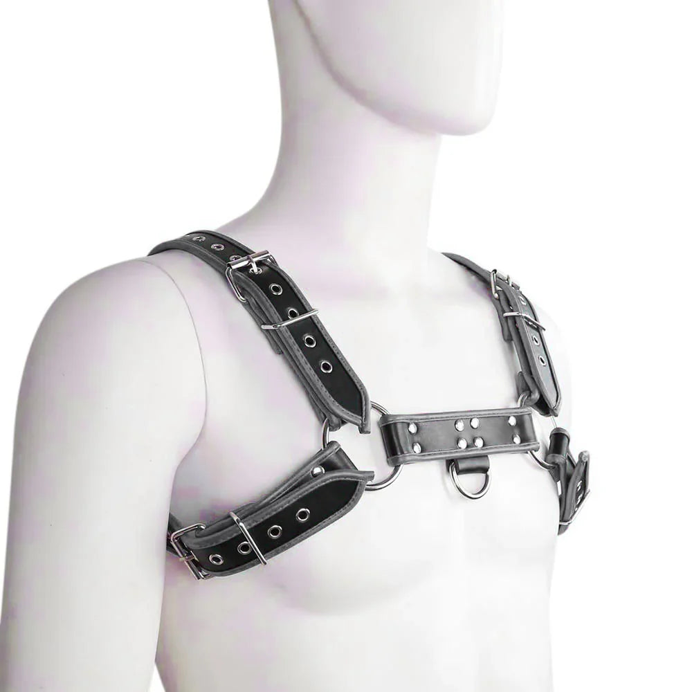 Black leather harness with contrast trim, metal buckles, grommets, and rings on a white mannequin.