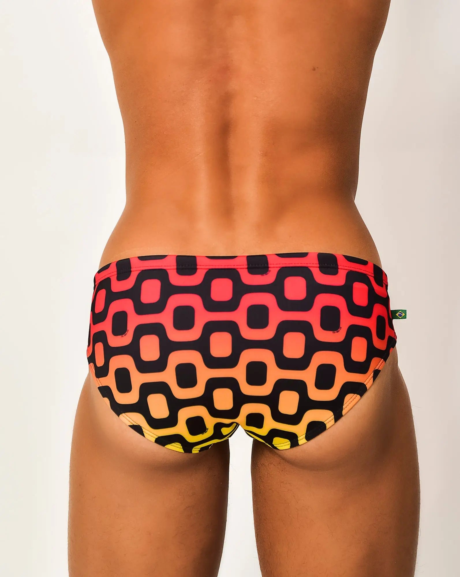 Leblon sunga men’s designer swimwear with vibrant geometric pattern in red orange yellow gradient on black fabric