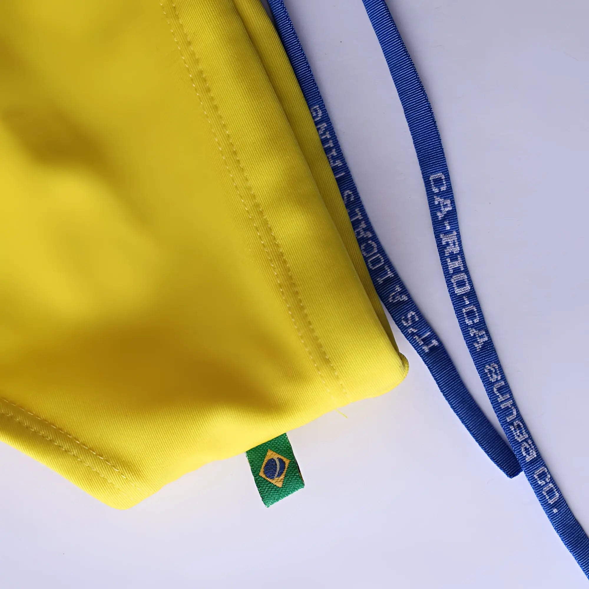 Lemonade yellow solid men’s swimming sunga with a green and blue brazilian flag tag for beachwear