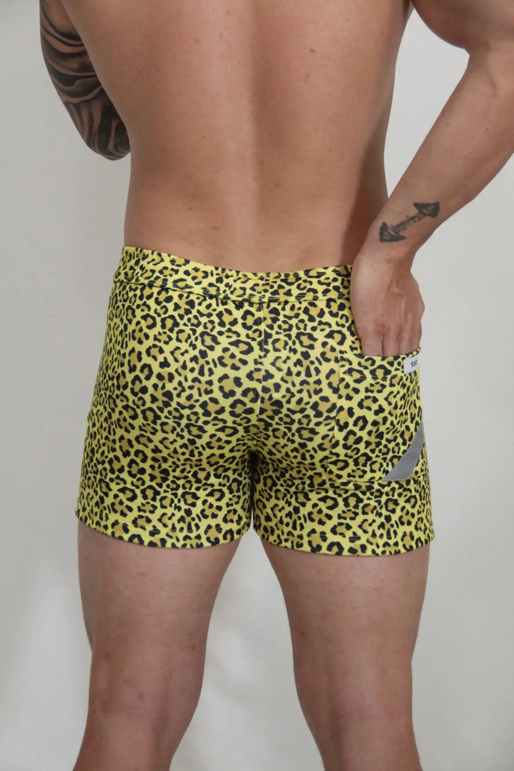 Yellow leopard-print fleece short with snug fit and small gray reflective patch on the side