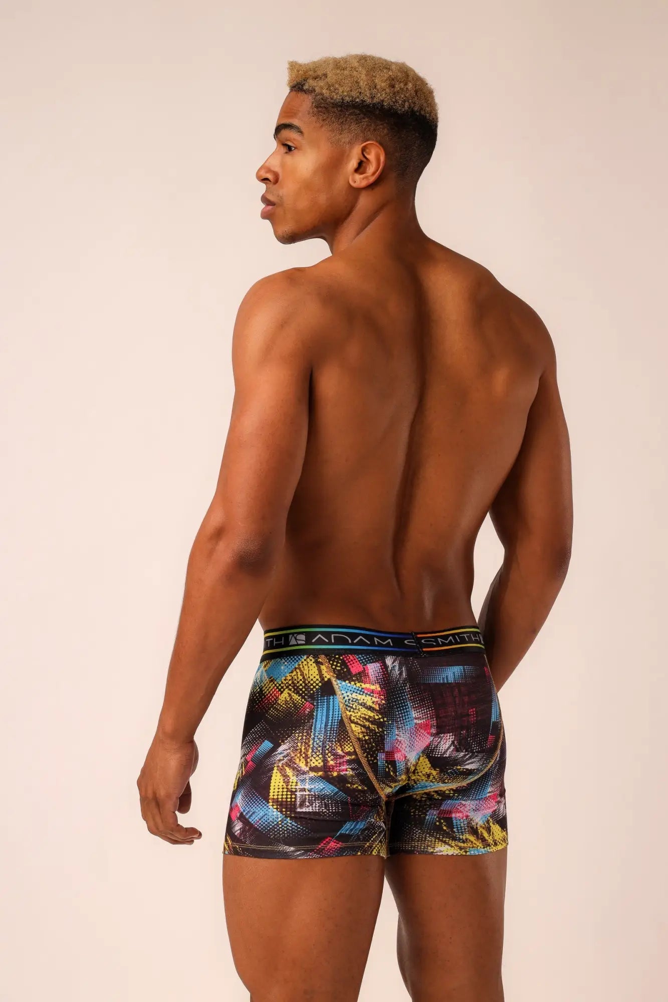 Adam Smith brand long trunks men’s boxer briefs with vibrant abstract geometric pattern in yellow blue pink on dark fabric