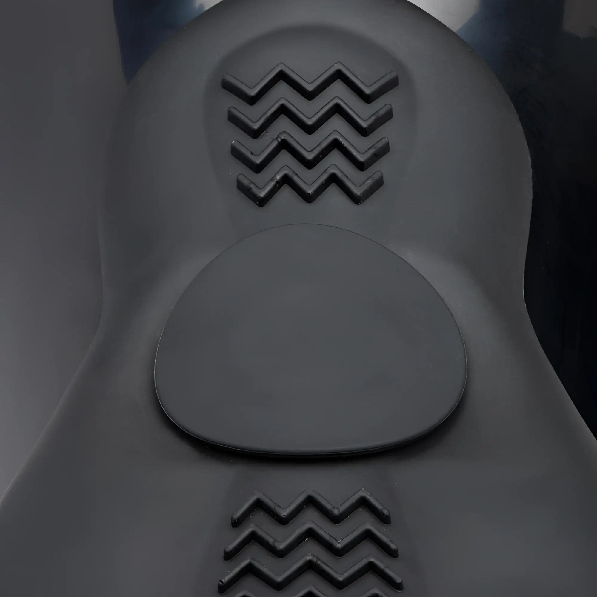 LoveBotz The Bucking Saddle: A black, ergonomic silicone seat with textured zigzag grip pads on a smooth surface.