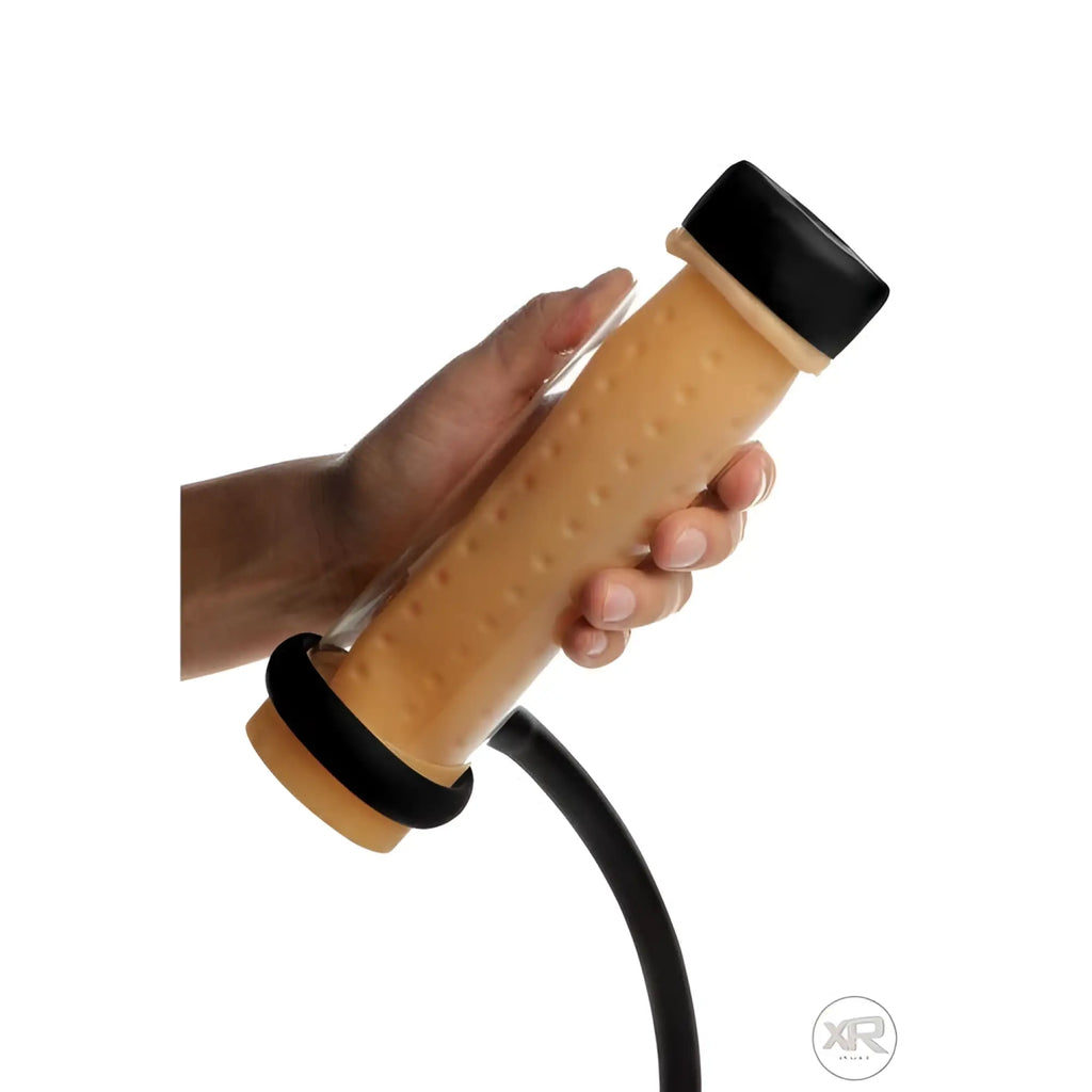 LoveBotz Milker Cylinder: A hand holding a tan, textured cylinder with black caps and a connected black tube.