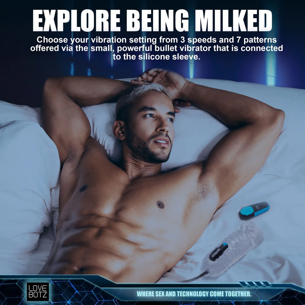LoveBotz The Milker Pro Edition: A shirtless man relaxing in bed next to a clear silicone sleeve and blue bullet vibrator.