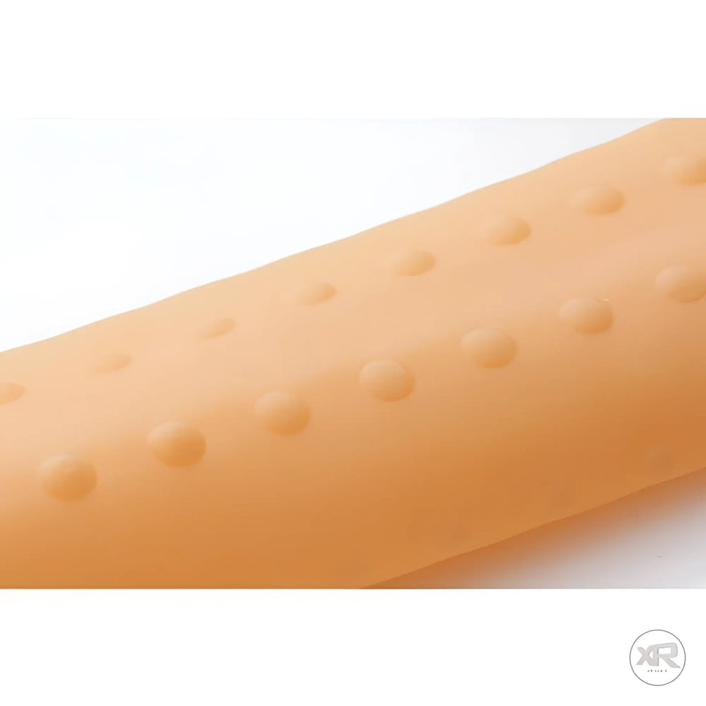 LoveBotz Super Milker sleeve: a textured, peach-colored silicone cylinder with raised circular patterns.