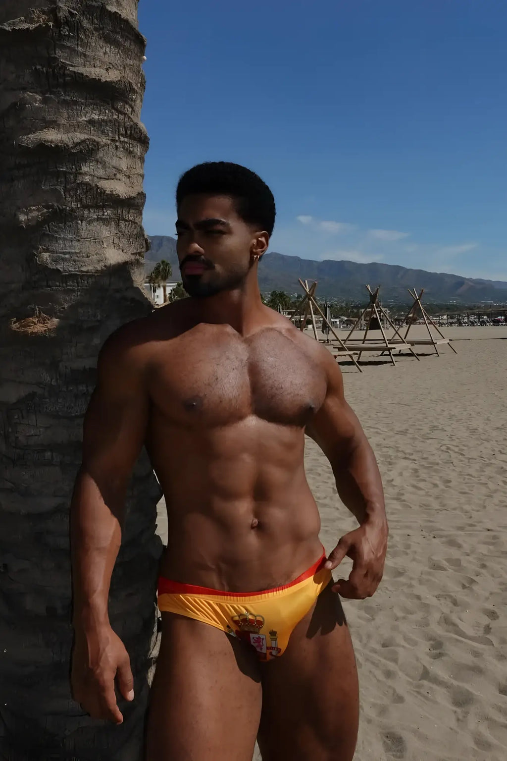 Yellow and red swim trunks lovesick briefs with small logo featuring spain flag colors for beachwear use