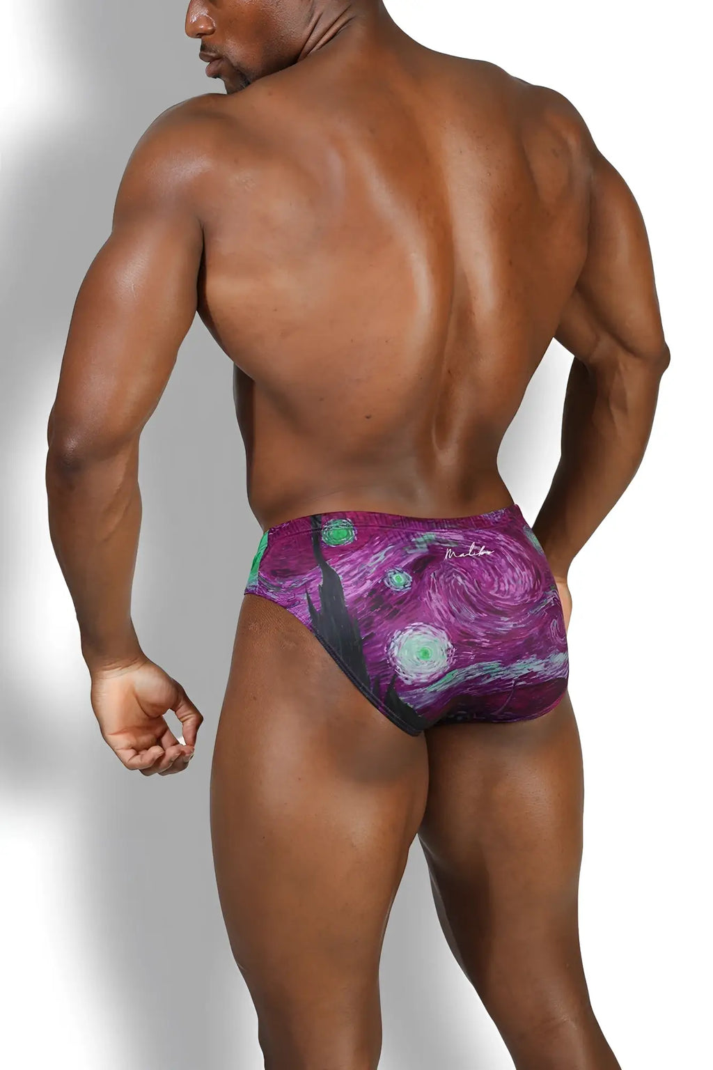 Purple and green patterned Lovesick Briefs swim trunks with swirling starry night design for spooky night wear