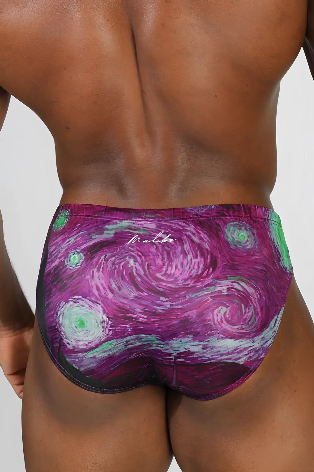 Lovesick briefs purple and green swirling starry night patterned swim trunks with black trim for spooky night style